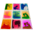 Kore Design Liquid Floor Tiles - Assorted Colors - Squares - 12" x 12" x 0.2" - Set of 9-Dance, play, and learn: These sensory Disc Tiles enclosed in liquid are durable, tear-resistant, and leak-resistant, ensuring resilience against games, dancing, and hopping. With a non-slip backing, they stay securely in place during play