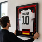 Frameworth Official FIFA World Cup 2026 Germany Jamal Musiala Framed Replica Jersey - 25.75" x 33.75"-Handcrafted in Canada by Frameworth Sports Marketing, established 1992, producing officially licensed sports memorabilia.