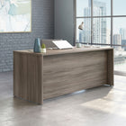 Sauder 71"W Affirm Desk - Hudson Elm-  Cord management system with two desk top grommet holes keep your desk clutter free